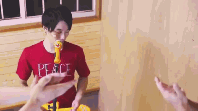 a man in a red shirt with the word peace on it is blowing bubbles .