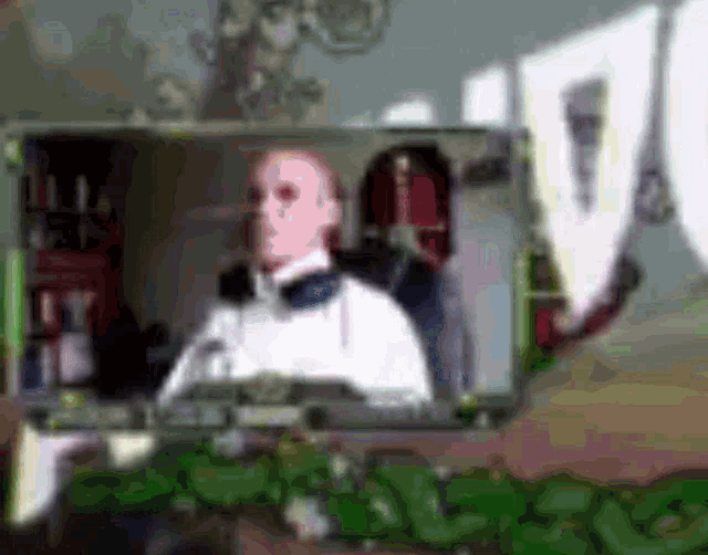 a blurry picture of a man in a tuxedo sitting in a chair .