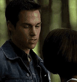 a man in a denim jacket is standing next to a woman .