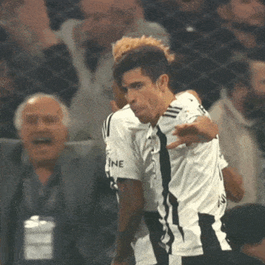 a man in a black and white jersey with the word ine on the sleeve