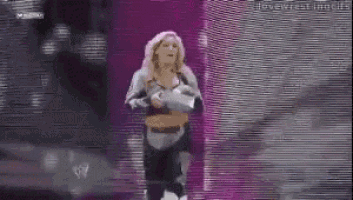 a woman in a knight 's armor is walking down a stage holding a sword .