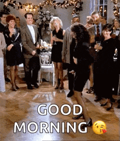 a group of people are dancing at a party and a woman is dancing in front of them .