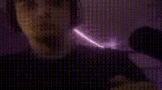 a close up of a person 's face with a purple light coming out of it .