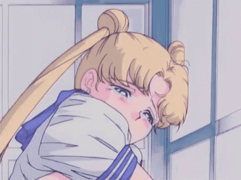 a girl in a sailor suit is crying and covering her face with her hands .