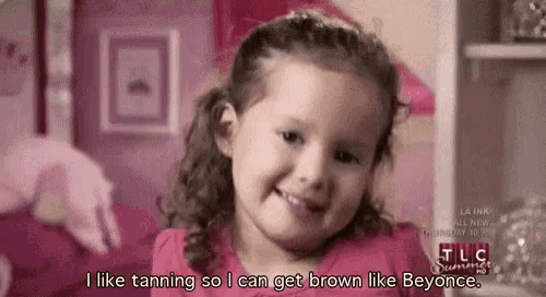 a little girl is smiling and talking about tanning .
