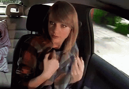 a woman is sitting in the back seat of a car and holding her hair .