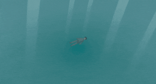 a man in a suit is floating on his back in the water