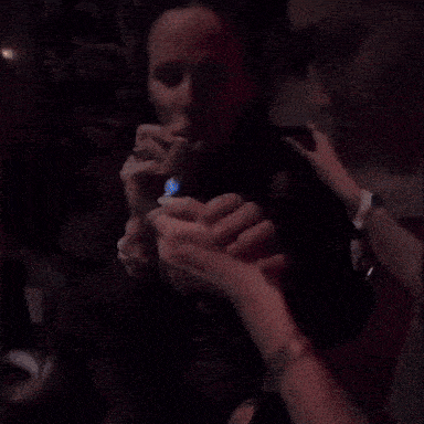 a man is lighting a cigarette with a lighter in a dark room