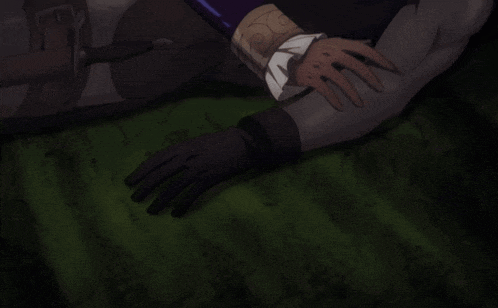 a person wearing black gloves is laying on a green blanket