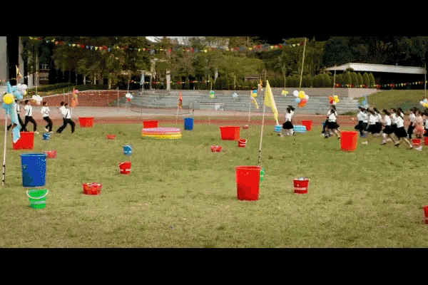 a group of people are playing a game with buckets and balloons