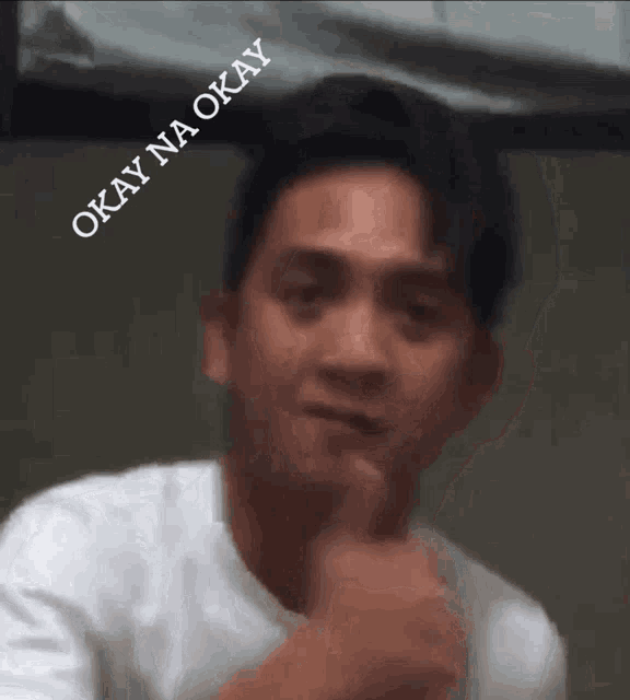 a man in a white shirt is giving a thumbs up and says okay na okay