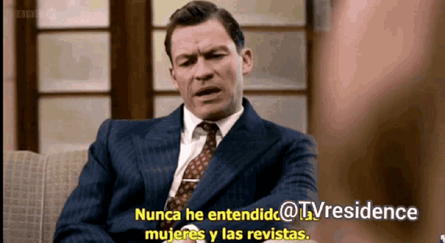 a man in a suit and tie is sitting on a couch and says nunca he entendido @tvresidence