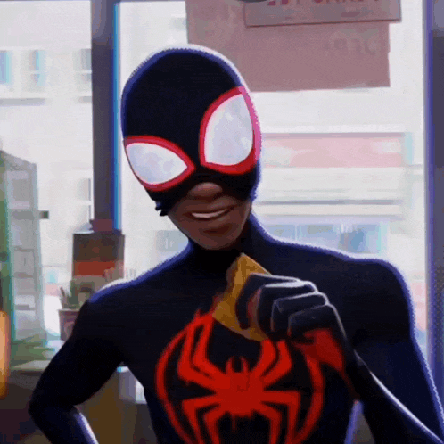 a man in a spider man costume is holding a piece of cheese