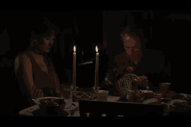 a man and a woman sit at a table with candles and a sign that says " no vendras conmigo "