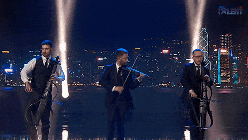 three men playing violins on a stage with the word talent on the bottom left