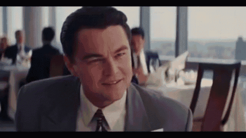 a man in a suit and tie is smiling in a restaurant .