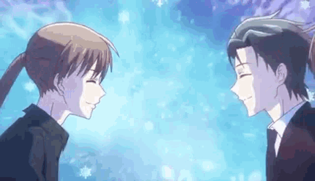 a man and a woman are looking at each other and smiling in front of a blue sky .