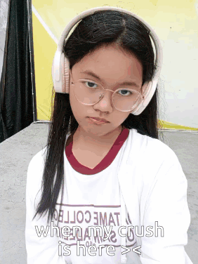 a girl wearing headphones and a shirt that says ' when my crush is here > < '