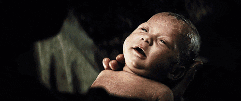 a man with a beard holds a baby in his hands