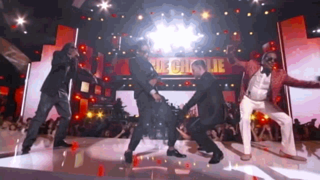 a group of men are dancing on a stage in front of a sign that says ' mechiole '