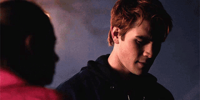 a man with red hair is standing next to another man .