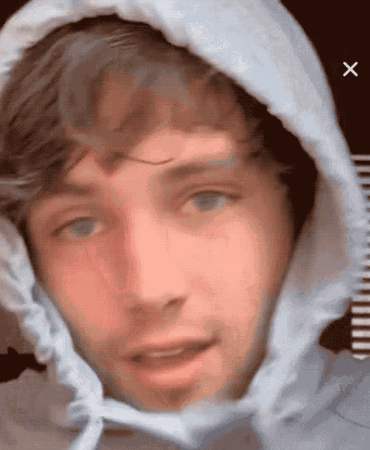 a close up of a man wearing a white hooded jacket