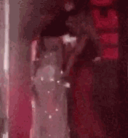 a woman in a red dress is standing next to a woman in a white dress on a stage .