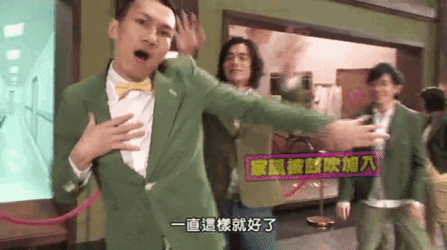 a man in a green suit with a bow tie is dancing