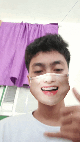 a young man wearing a face mask is smiling