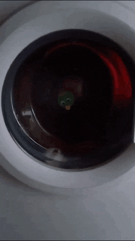 a close up of a washing machine with a green penguin on the door