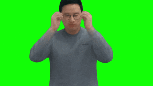 a man wearing glasses and a grey sweater has the word columbia on his shirt