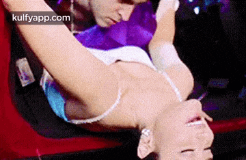 a man is kissing a woman 's neck while she is laying on a bed .