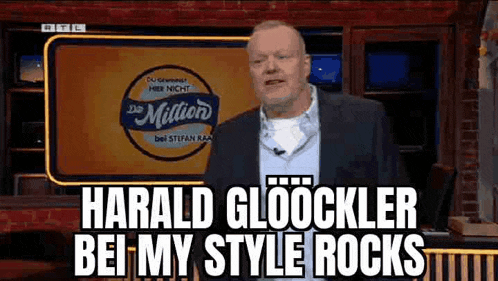 a man in a suit is standing in front of a sign that says `` harald gloocker bei my style rocks '' .