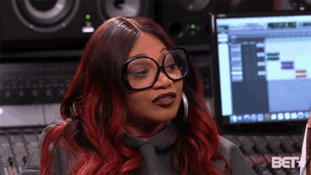 a woman wearing glasses is sitting in front of a computer screen that says bet on it