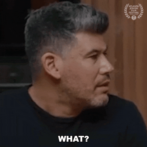a man in a black shirt says what in front of a laurel wreath
