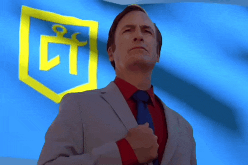 a man in a suit and tie stands in front of a blue and yellow flag