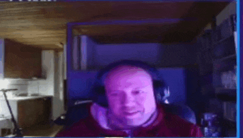 a man is wearing headphones while sitting in front of a computer screen .