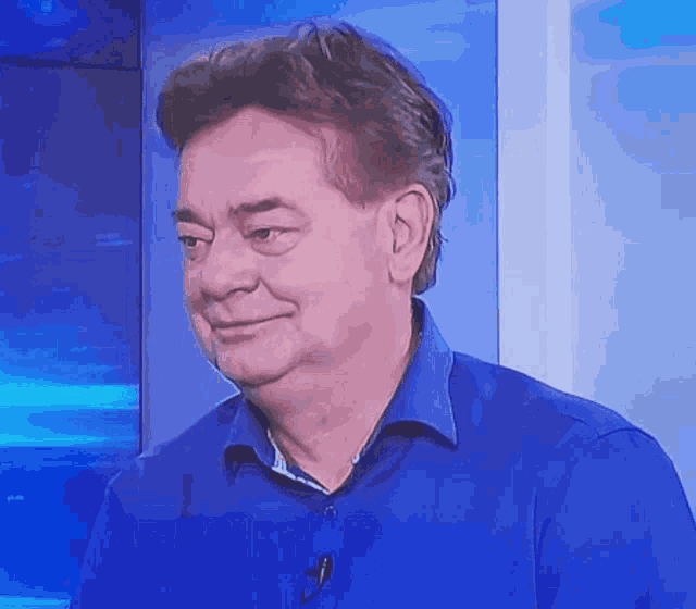 a man wearing a blue shirt with a microphone on his neck