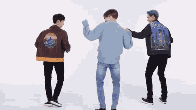 three men are standing next to each other and dancing .