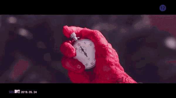 a woman in a red lace glove is holding a stopwatch with the number 12 on it