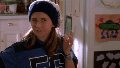 a girl wearing a beanie and a jersey that says fc