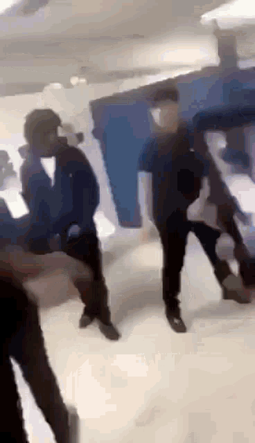 a group of people are standing in a room and dancing .