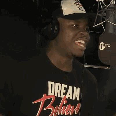 a man wearing headphones and a baseball cap says i told her breath stinks