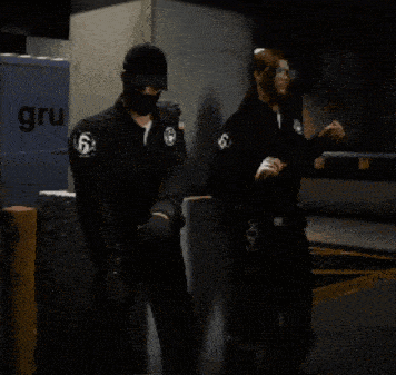a man and a woman are standing in front of a gru truck