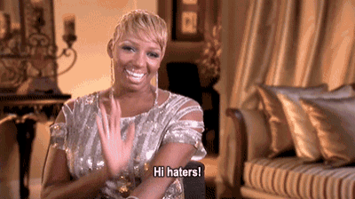 a woman in a sequined dress says hi haters in a living room