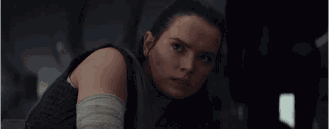 a close up of a woman 's face with a serious look on her face in a dark room .