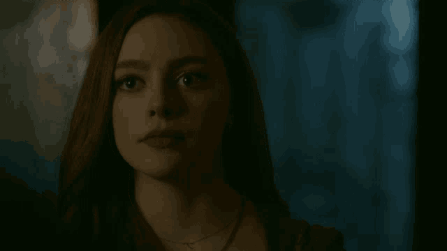 a close up of a woman 's face with red hair