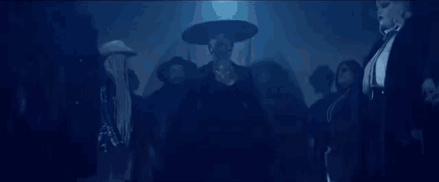 a group of people are standing next to each other in a dark room in a dark room .