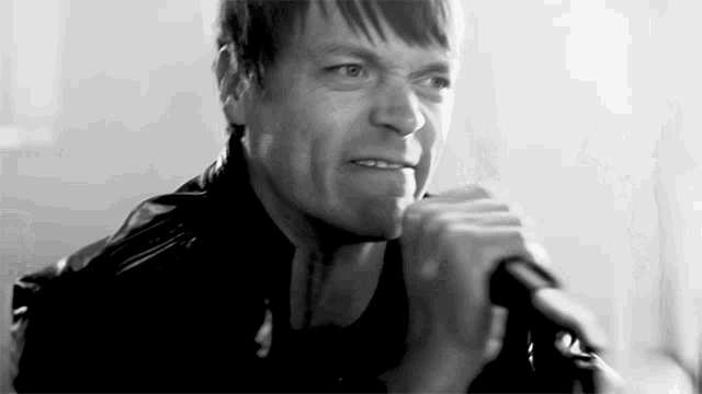 a man is singing into a microphone and making a funny face