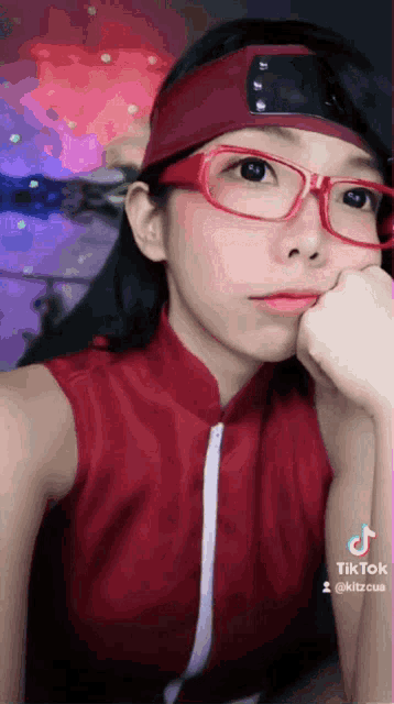 a girl wearing glasses and a headband is taking a selfie .